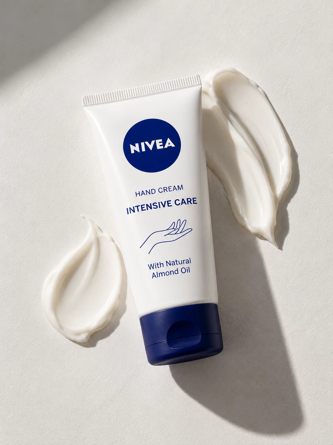 Nivea Intensive Care hand cream tube framed by white cream swirls