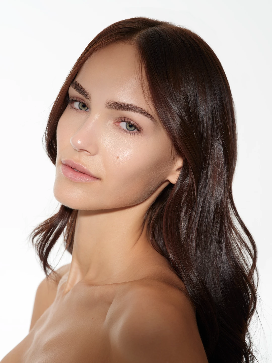 Julia Wess with loose brown hair and luminous skin against white