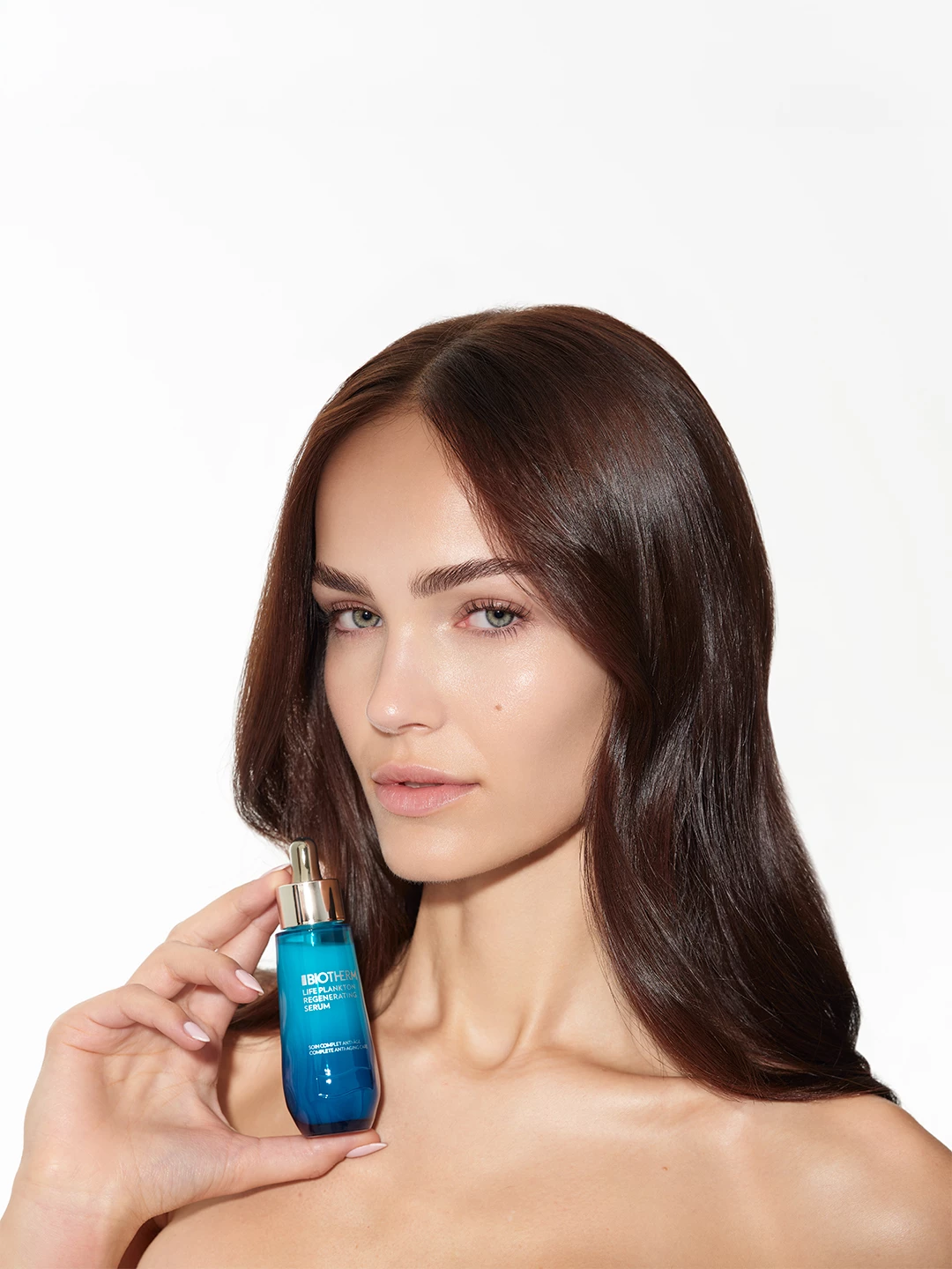 Julia Wess holding a blue Biotherm serum bottle beside her face