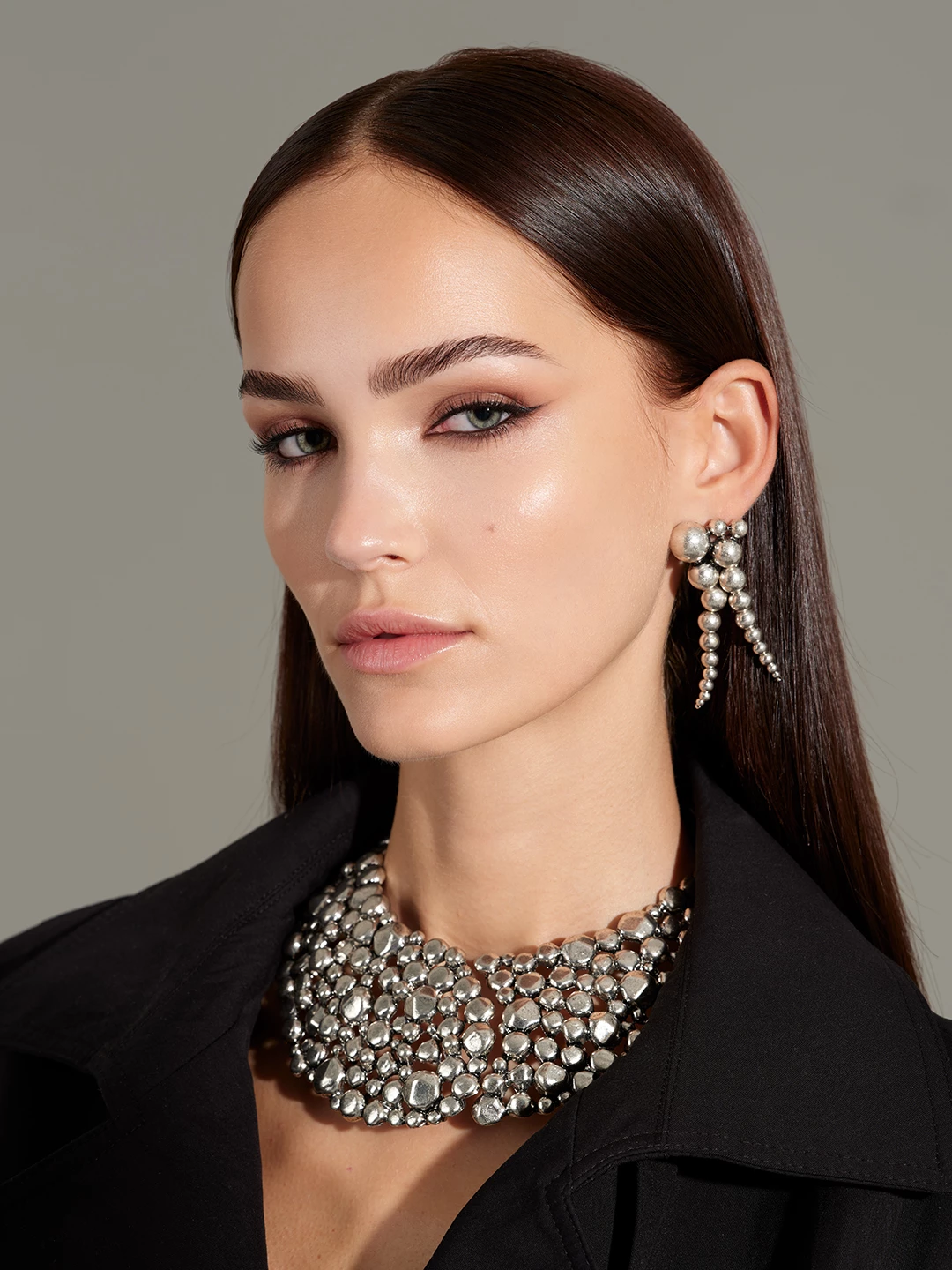 Julia Wess in a black jacket with statement silver earrings and necklace