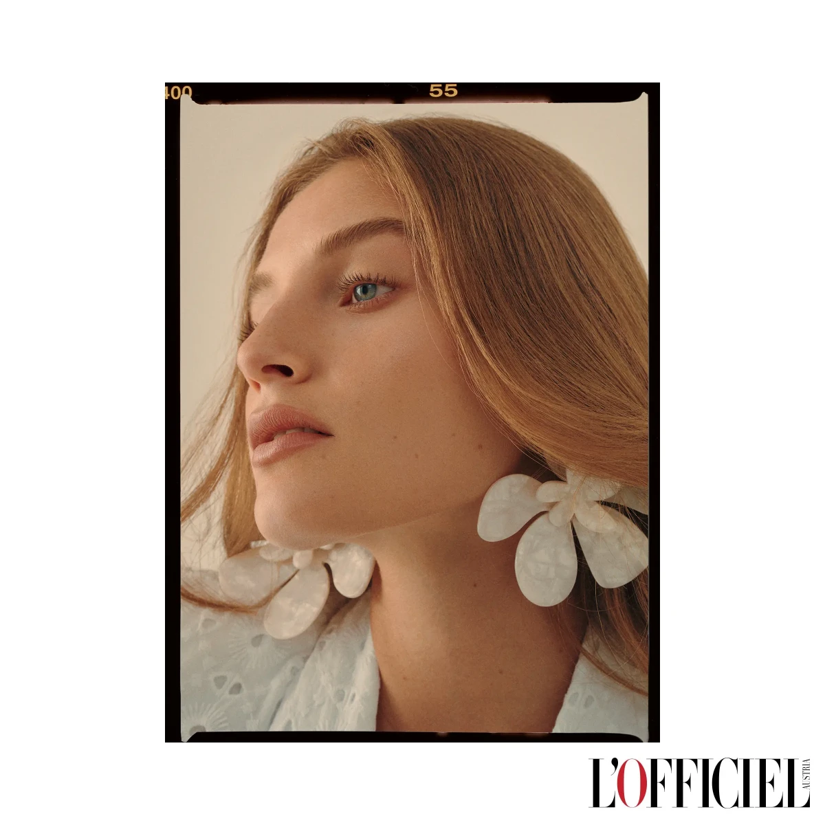 L’Officiel beauty page showing a model with white flower-shaped earrings